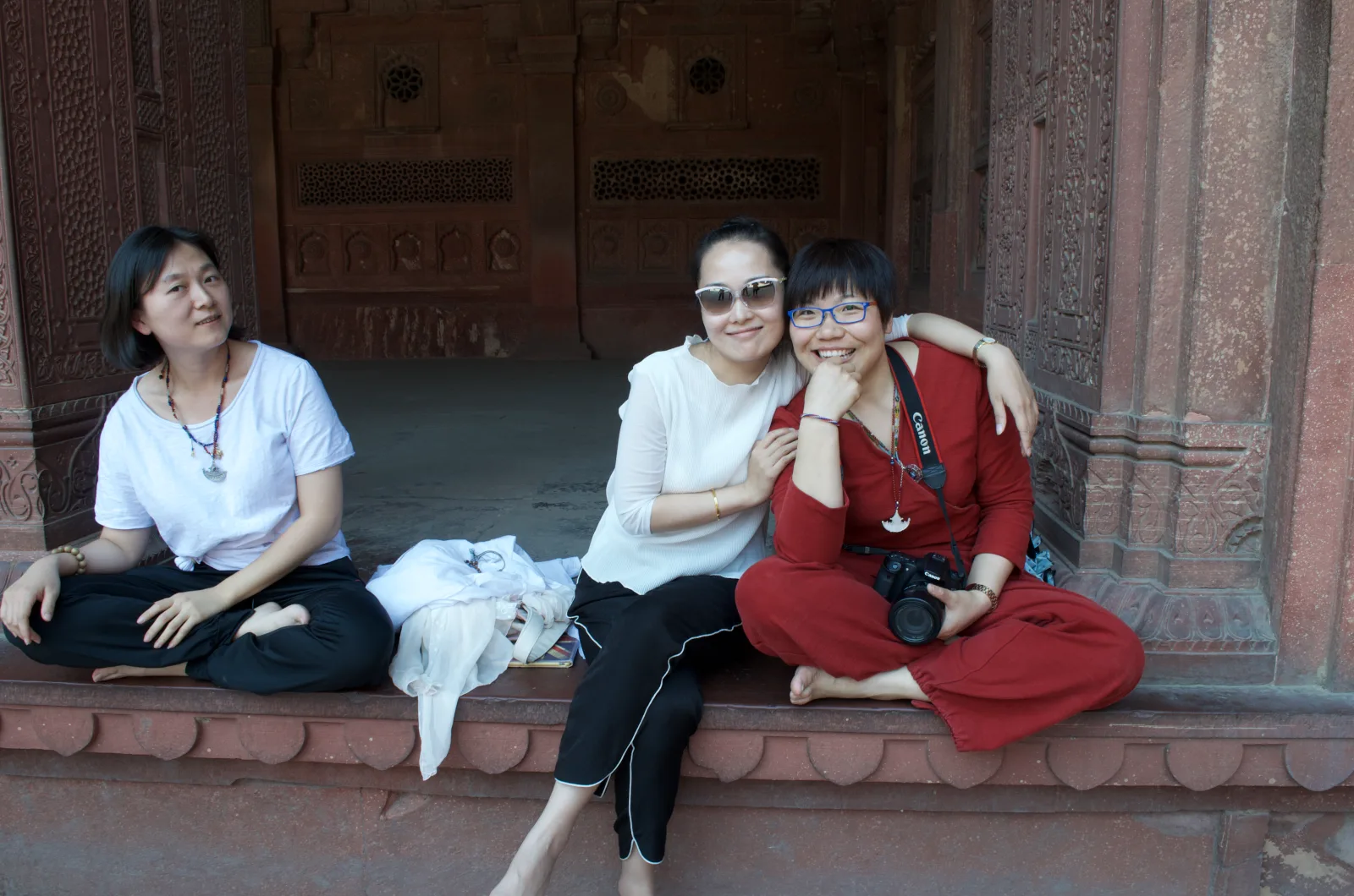 Three of our guests sitting together in a carved red sandstone palace at Agra Fort