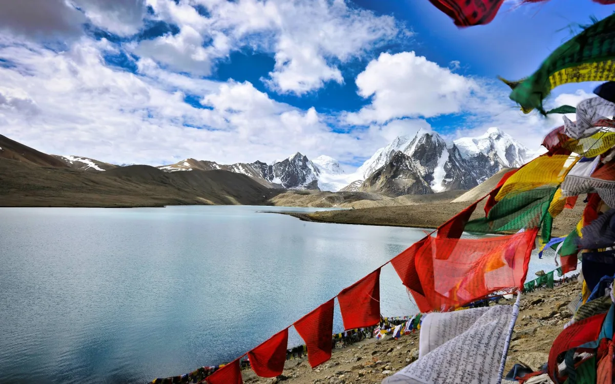 Prayer flags beside Gurudongmar Lake, below snow peaks in North Sikkim